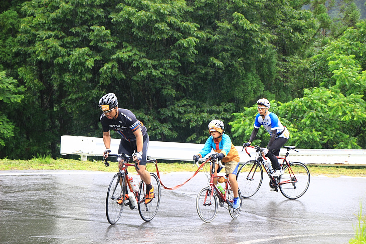 自転車同士を繋ぎ息子さんを引っ張るお父さん