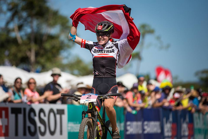 XCO女子ジュニア　国旗を掲げてフィニッシュするラウラ・スティッガー（オーストリア）