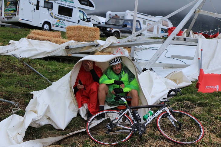 崩壊したレース観戦ブースの残骸で暖を取るおじさん