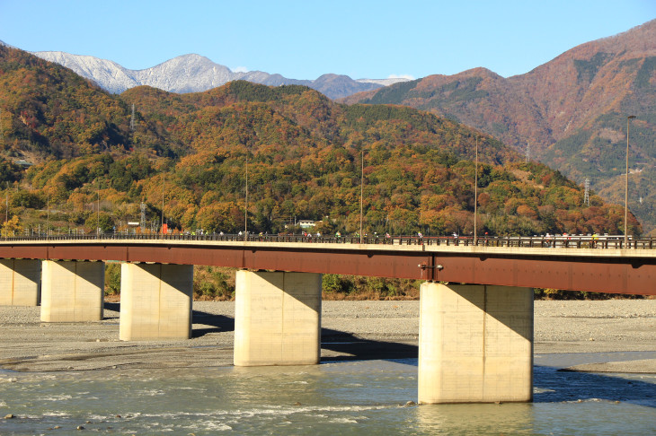 富士川の向こうにある第一エイドへ向けて橋を渡る