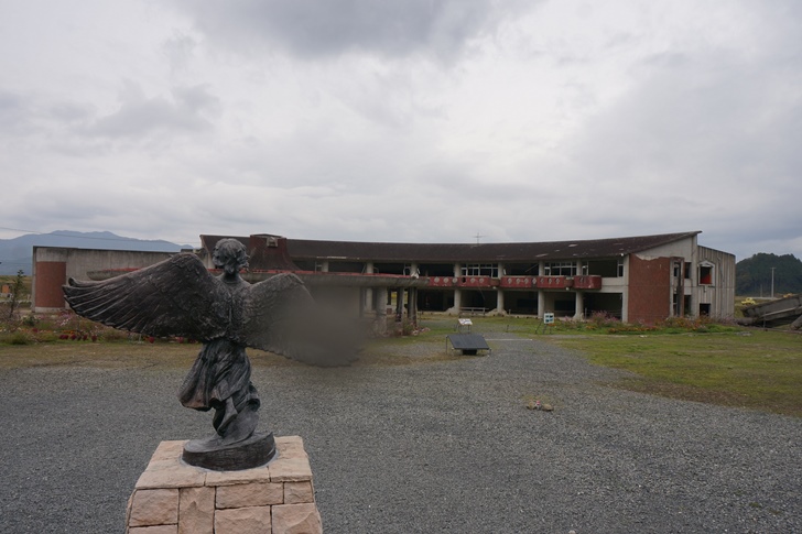 大破した校舎のそばに建つ慰霊碑。こちらの気持ちに代弁するかのように空も泣き出しました…