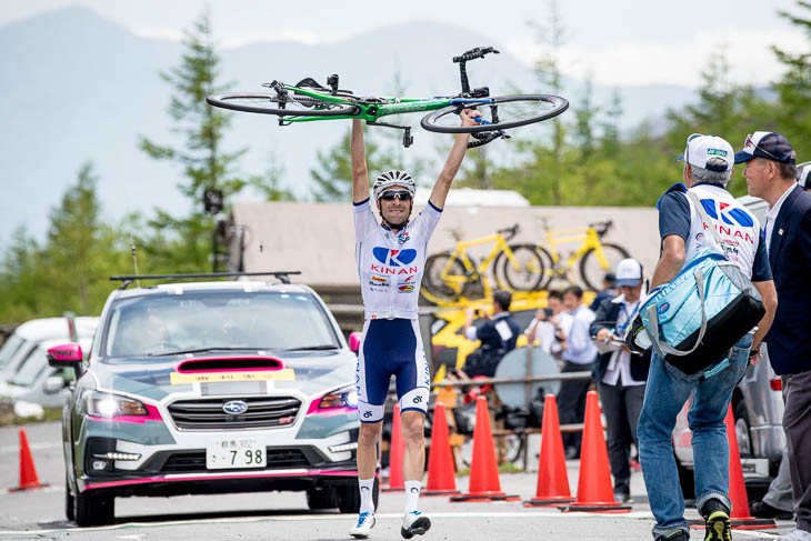 トップでフィニッシュし、自転車を高々を掲げるマルコス・ガルシア（キナンサイクリングチーム）