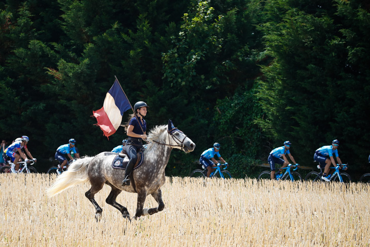 フランス国旗を持って馬を走らせる