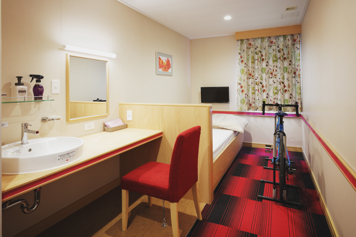 デラックスシングルの客室には自転車をそのまま持ち込めて、専用スタンドで設置できる。部屋も清潔で余裕のある広さ