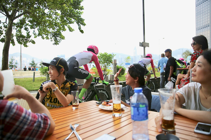 日本から観戦に訪れたファンの姿も。海沿いのカフェ横を、レースに向かう選手たちが通り過ぎていく