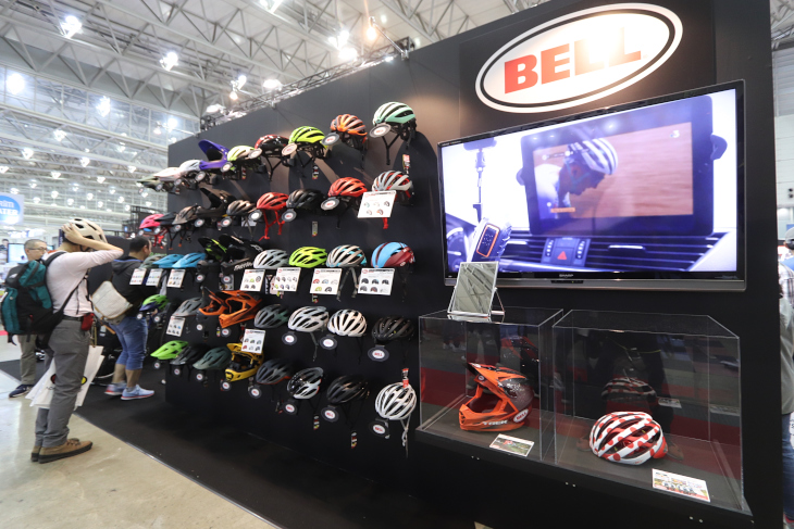 ロードとMTBモデルのヘルメット各種を並べたベル。マイヨアポアカラーの特別品も展示