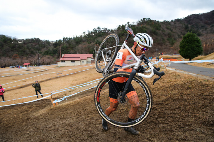 男子マスターズ40-44 バイクを担いでキャンバーをクリアする筧五郎(56サイクル)