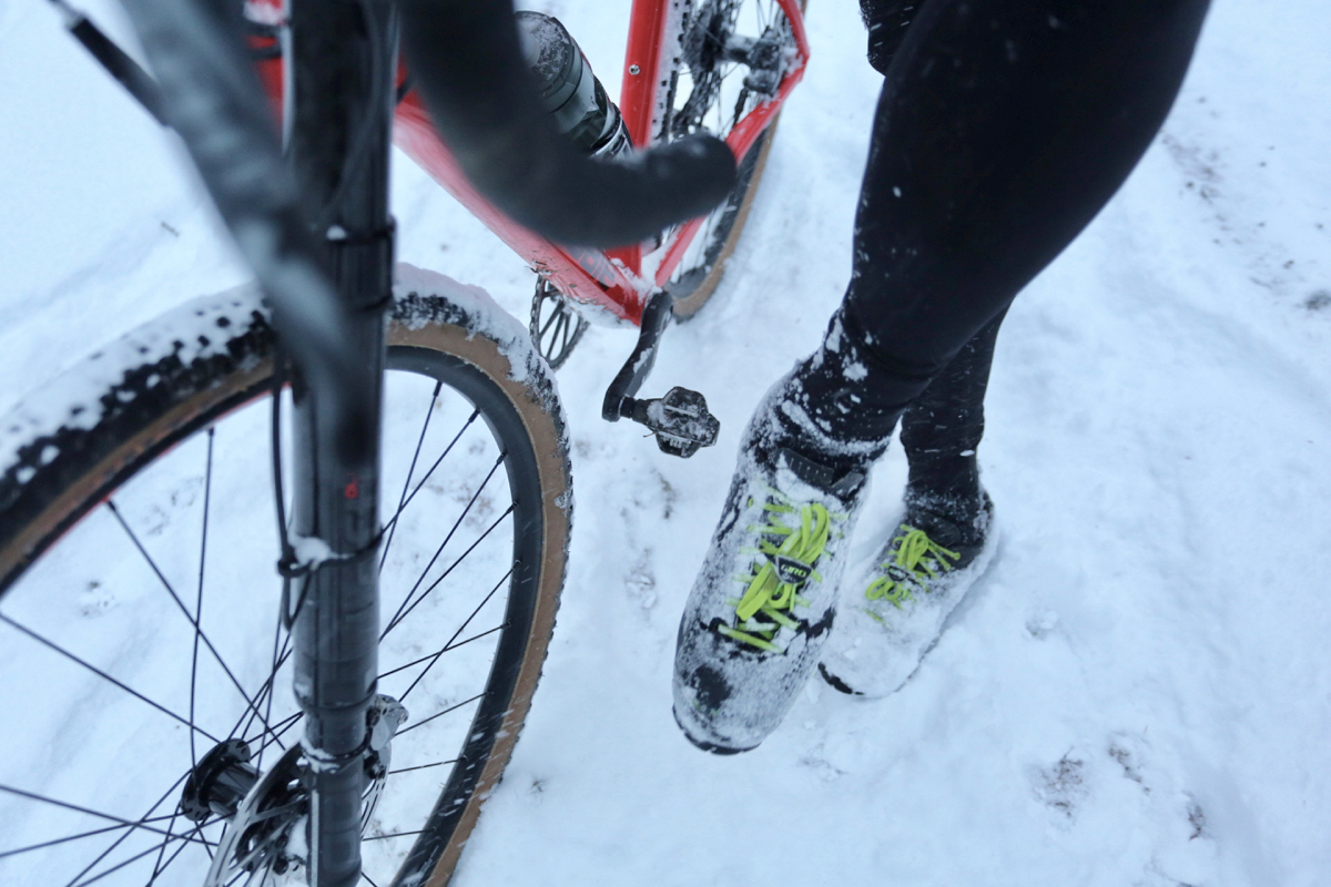 降車を強いられる雪の激坂登り。クリートの雪を落とさないとペダルがはまらない