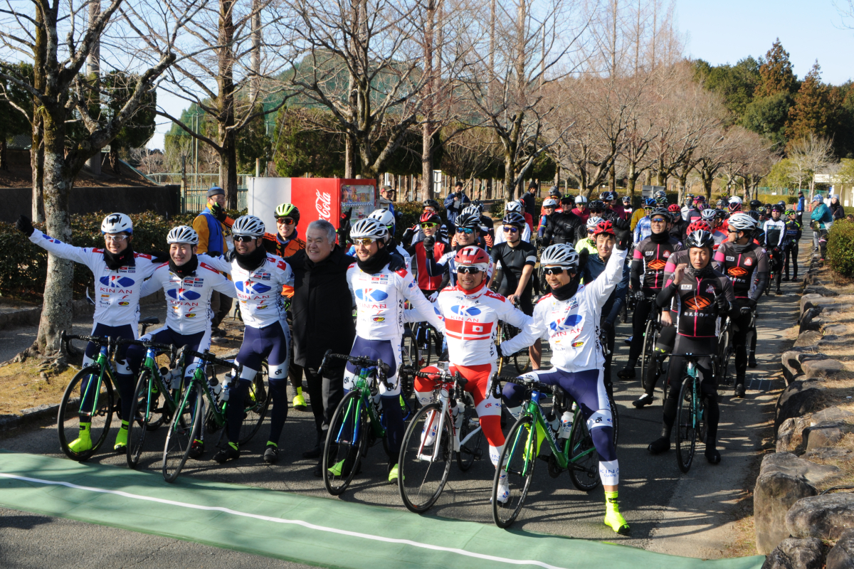 穂積亮次新城市長とホストチームのキナンサイクリングチームの選手たちが並び、60分エンデューロ前に参加者と記念撮影
