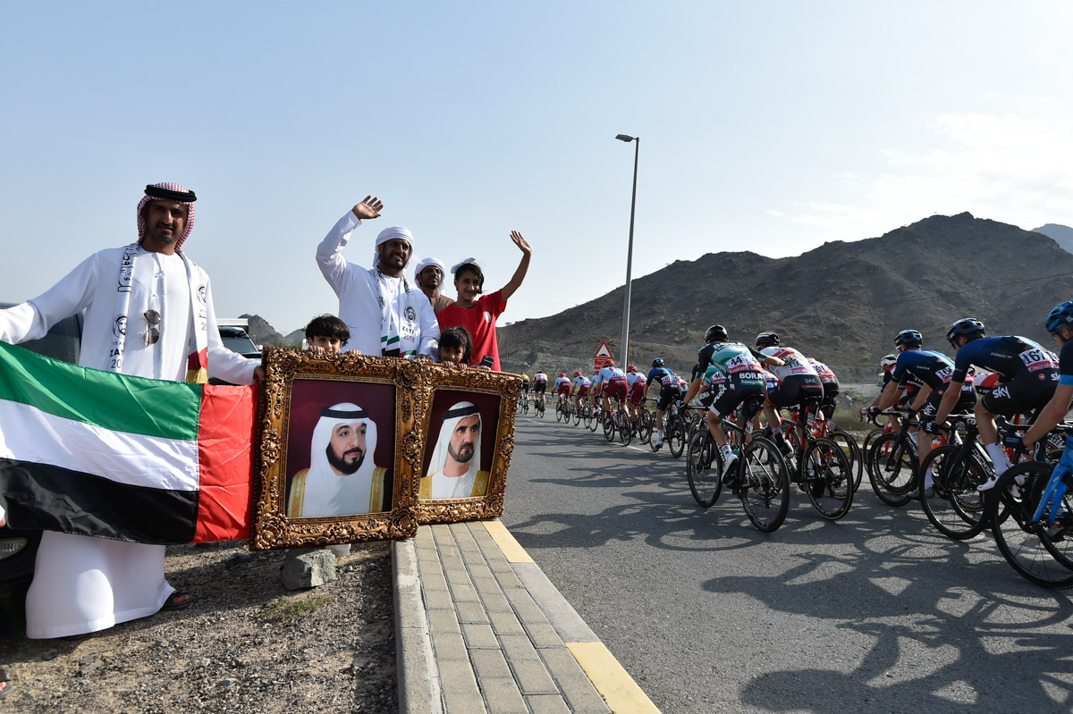 UAE（アラブ首長国連邦）の国旗と皇族の写真を持って応援