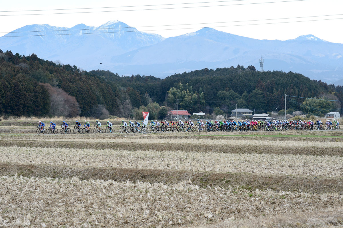 雪が残る那須連山をバックに走る集団