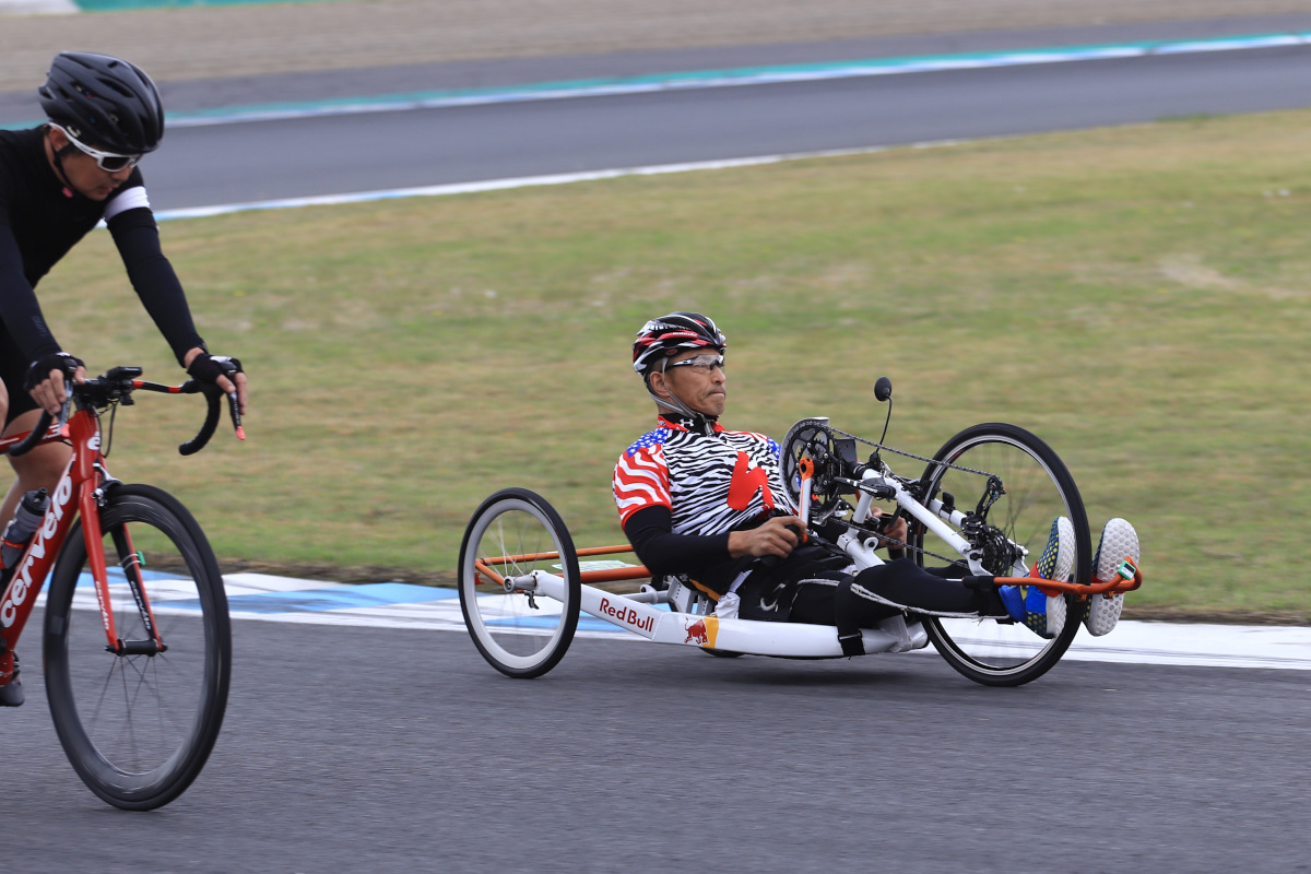 低い姿勢でコースを駆け抜けるハンドサイクルのライダー