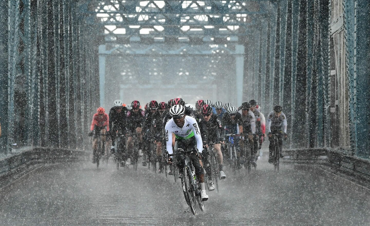 激しい雨のなかペースを上げるメイン集団