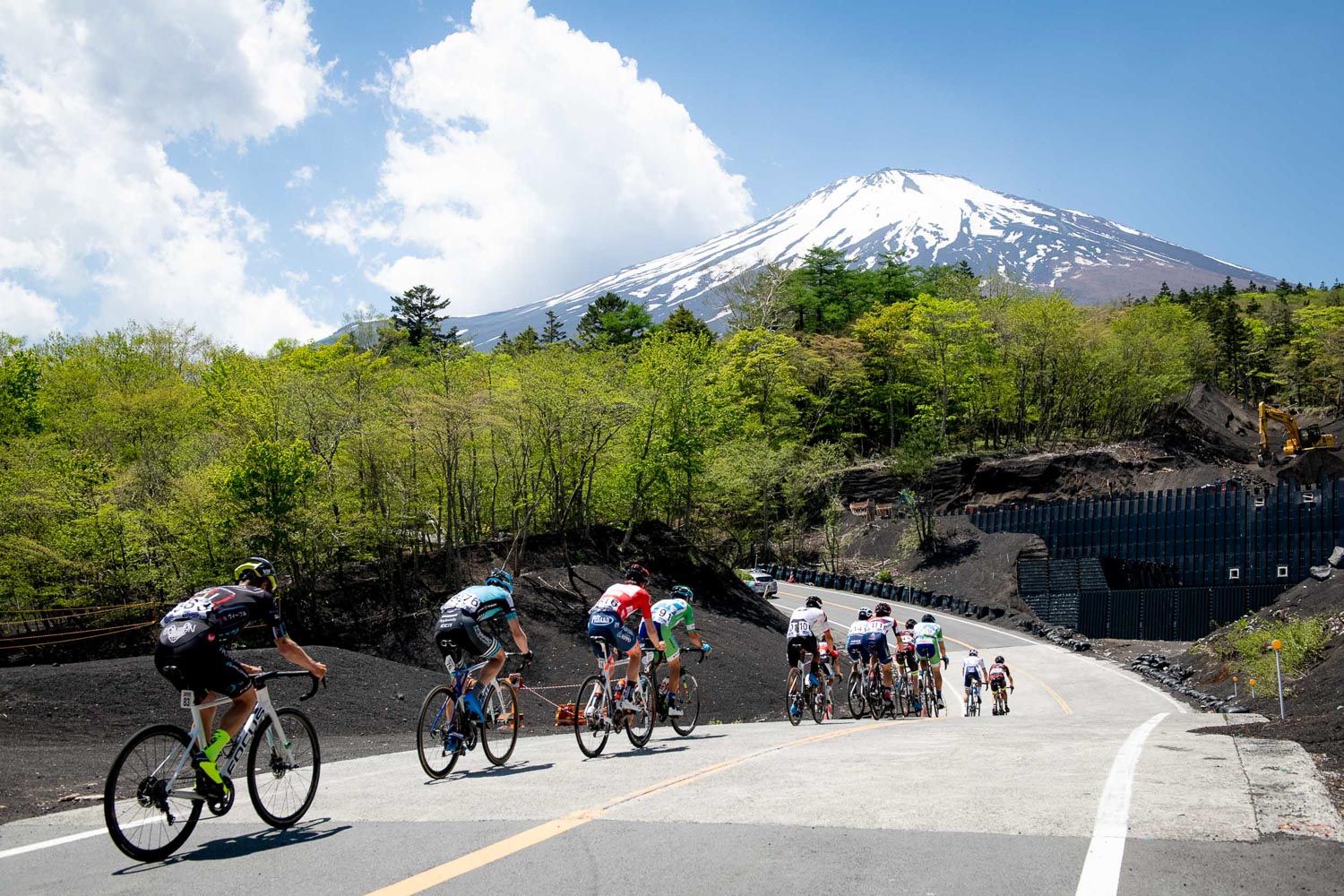 ふじあざみラインの旧馬返付近を行く集団　青空をバックに富士山がそびえる