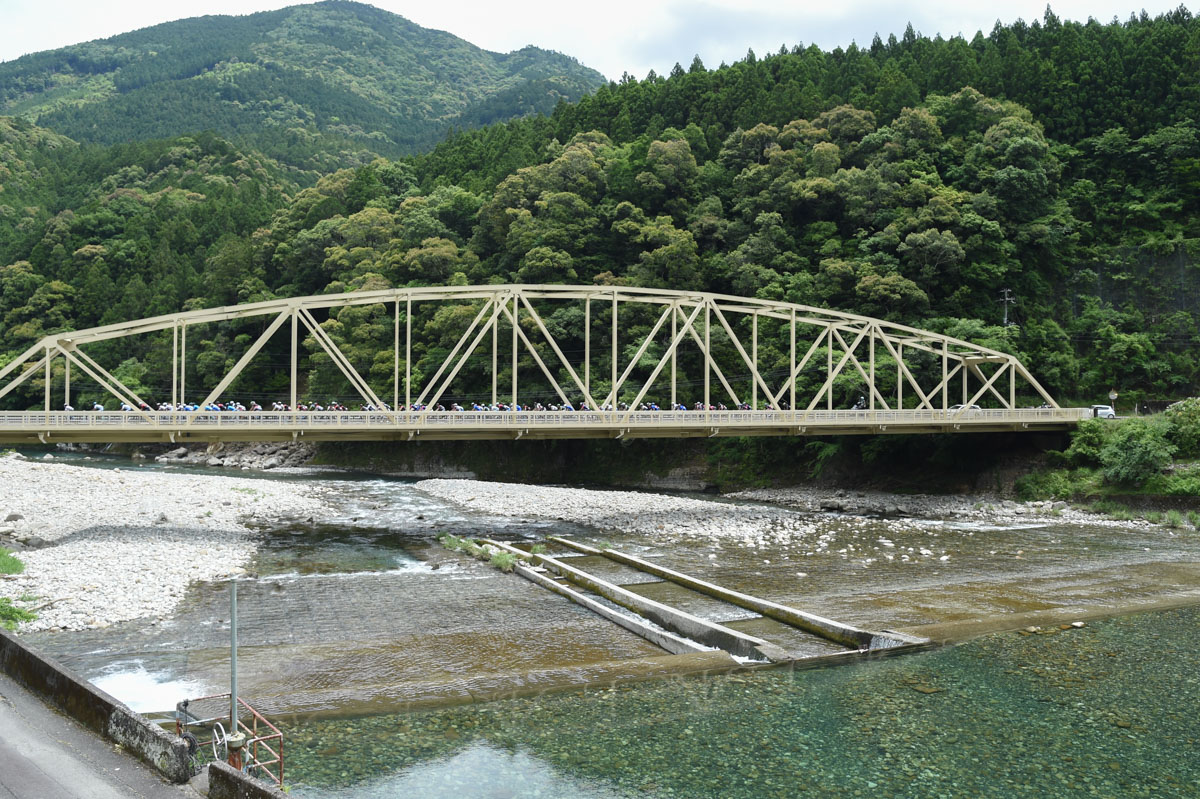 澄んだ水の赤木川を渡る集団