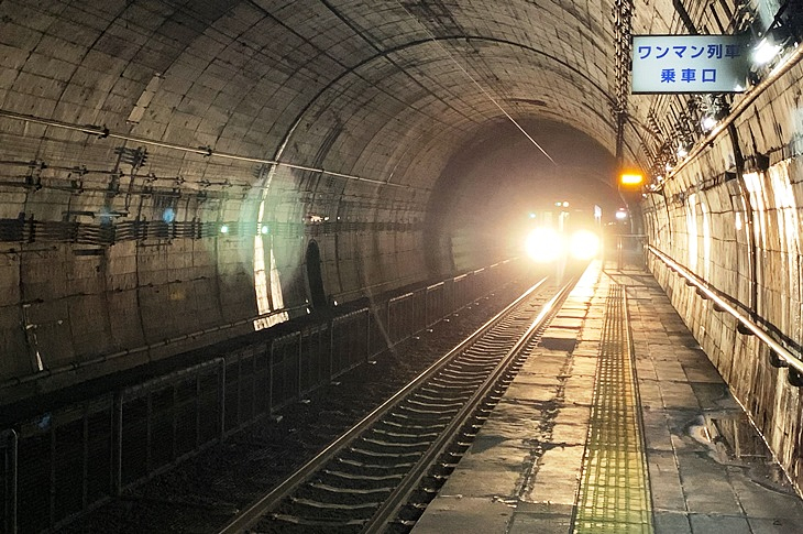 地底深くのトンネル内にホームで待っていると、列車の音と光がみるみる近づいてきた!