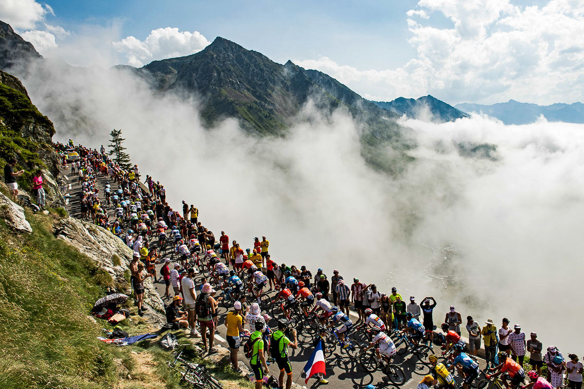 雲が湧き上がるトゥールマレー峠を登る集団