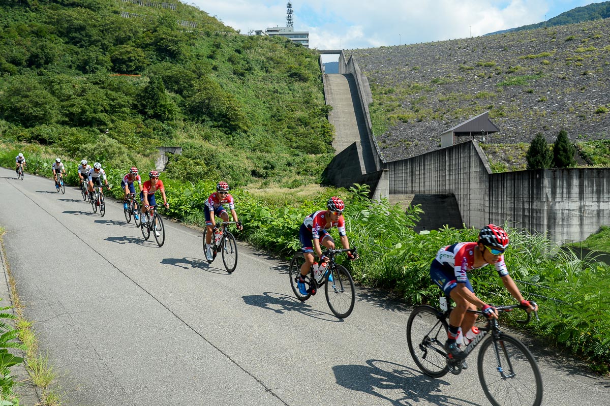 スキーのジャンプ台のような三国川ダムの放水路を背にダウンヒルしていく集団