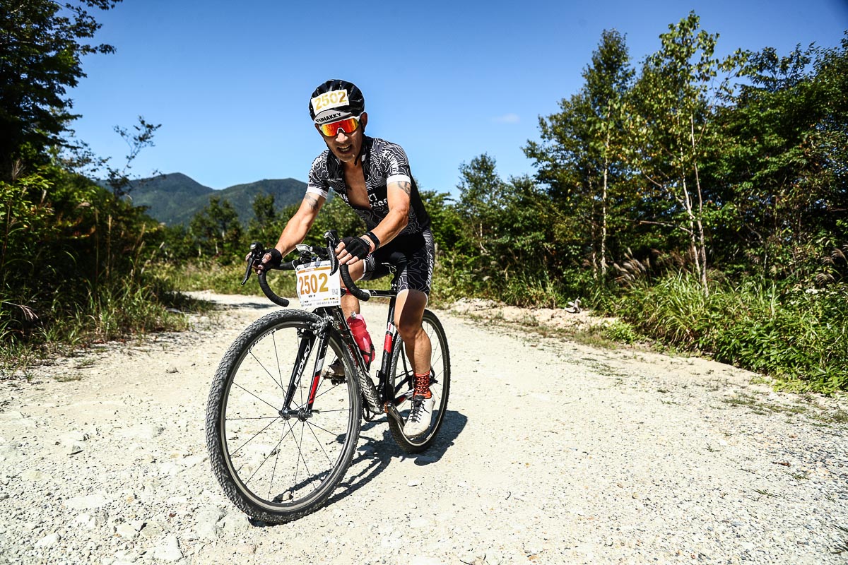 ガレた林道を走るグラベルクラス100kmの参加者