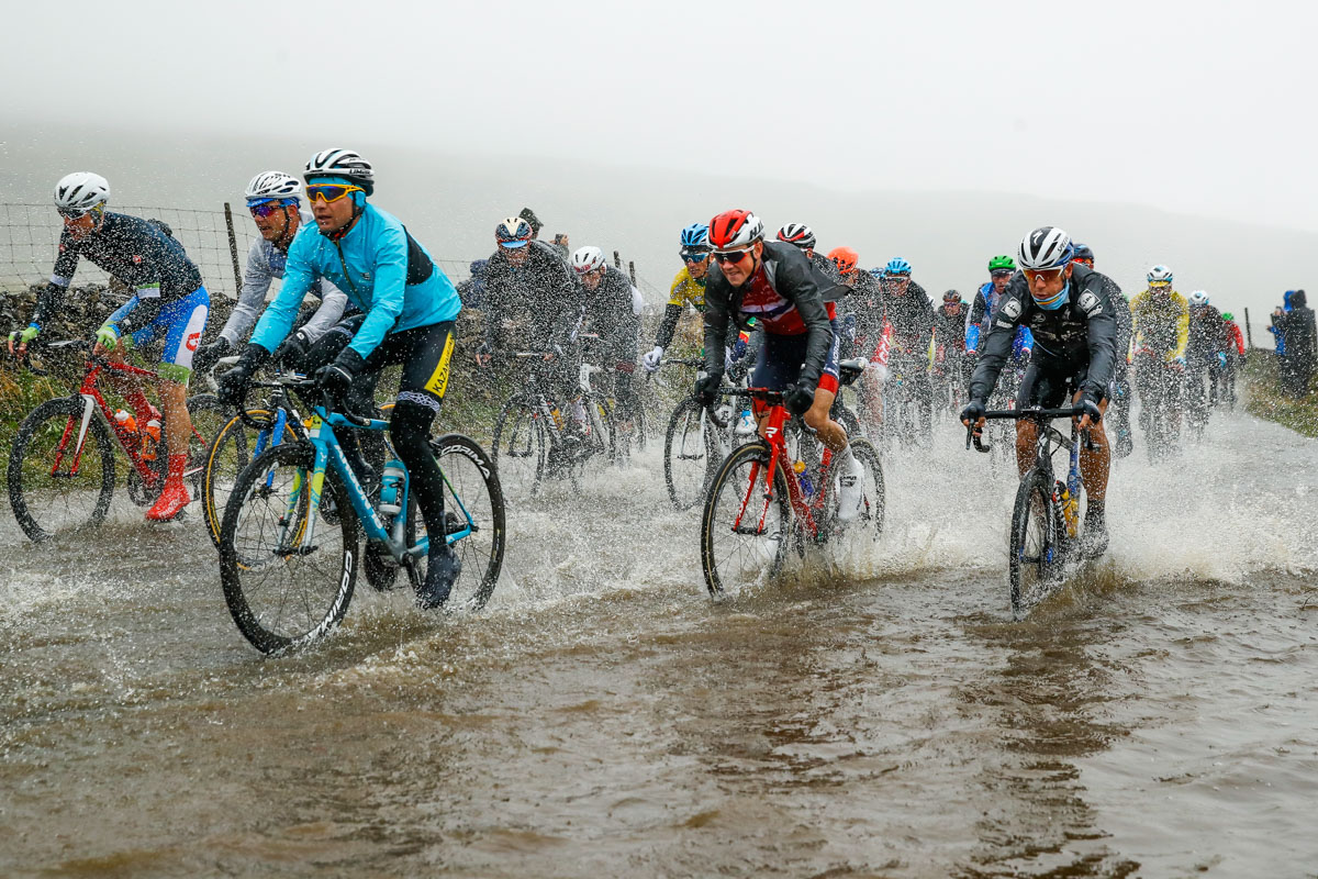 男子エリートのレースは豪雨の中で。水たまりの中を行く選手たち