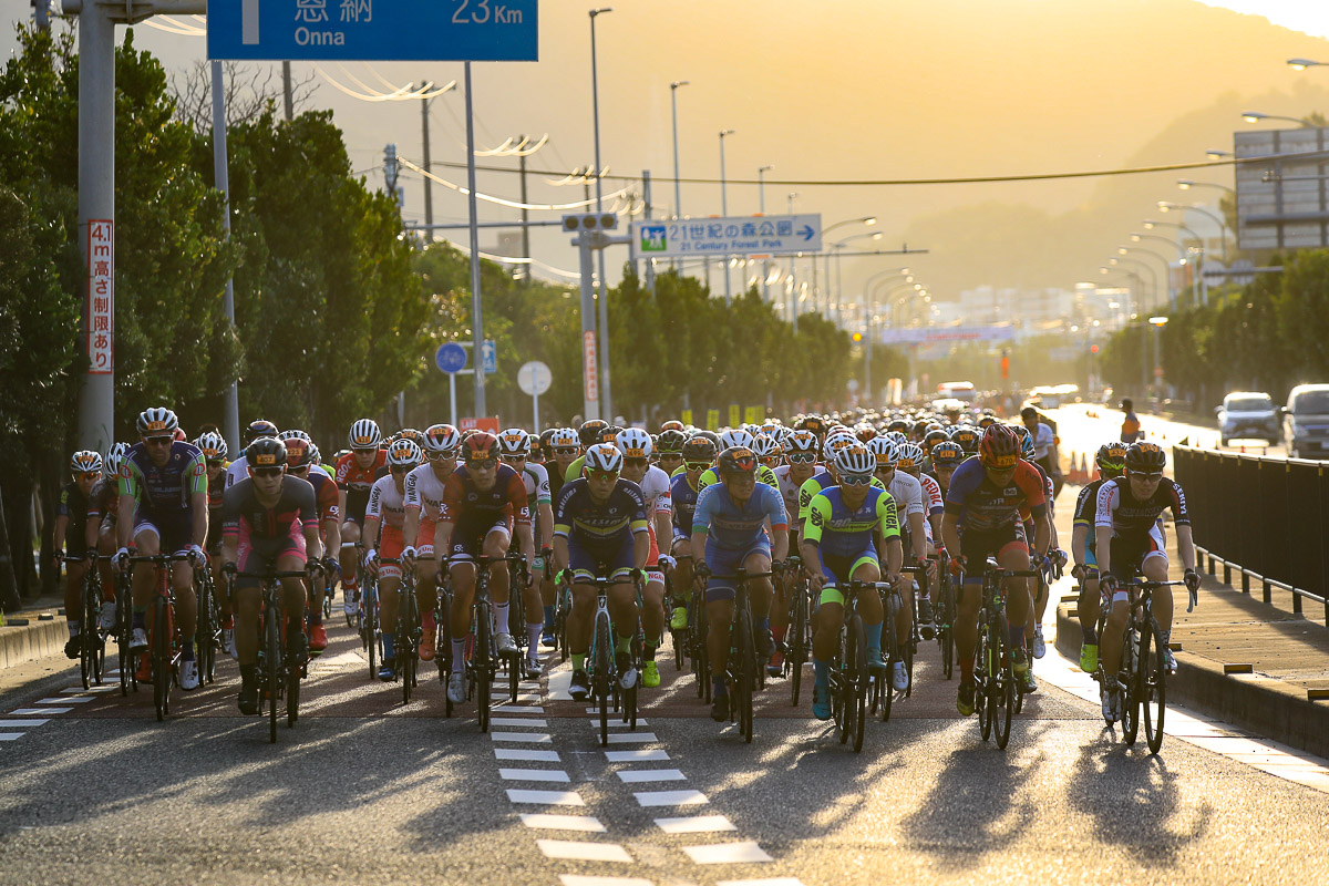 朝陽を浴びて名護市街をスタートしていく市民210kmの集団