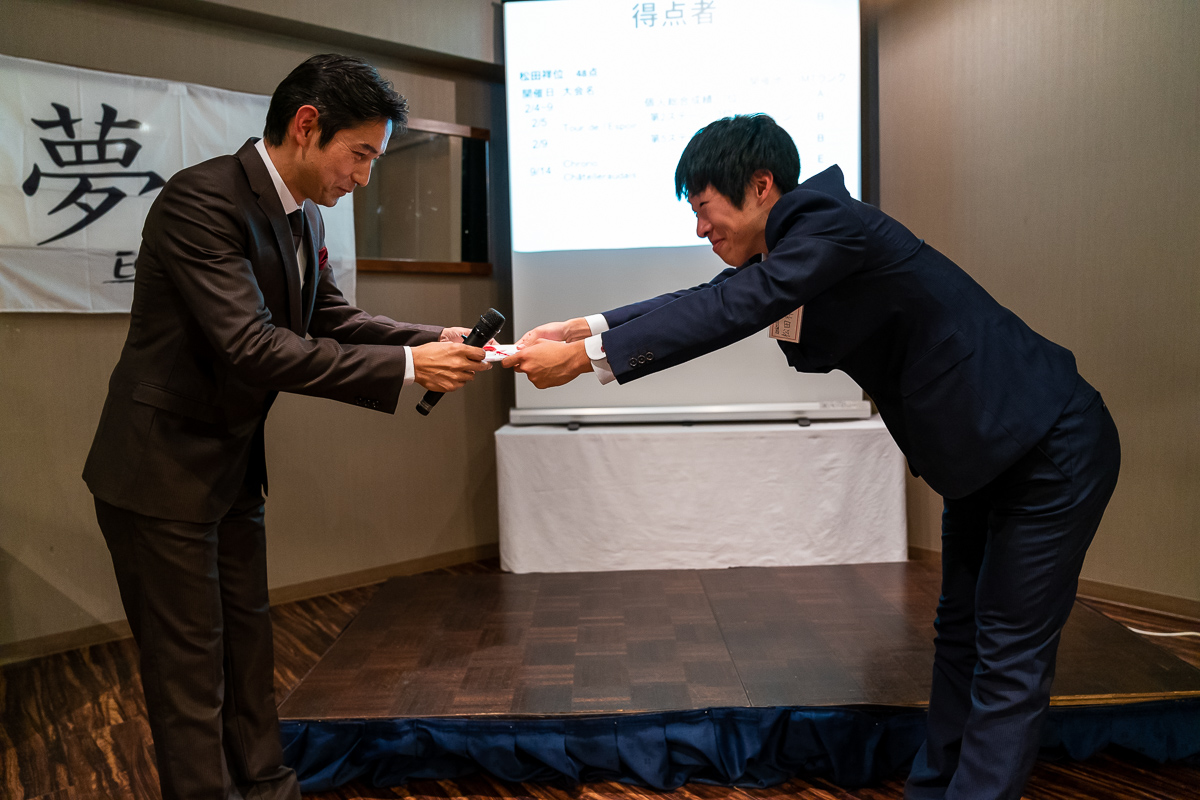 なぜか学校の卒業証書授与式のごとく賞状を受け取る松田祥位。浅田監督も思わず「卒業おめでとう！」（まだエカーズ卒業ではありません）