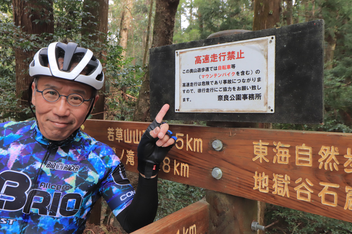 看板には「自転車は危険な高速走行はしないこと」と注意書きがある