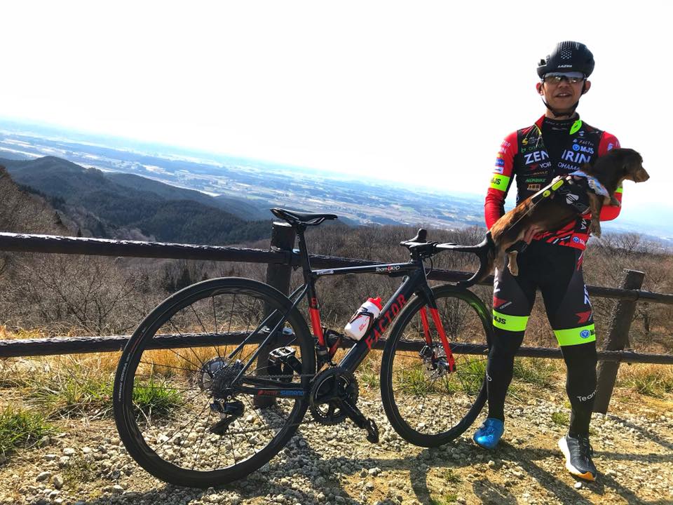 今は外で自転車に乗れるまでに回復した吉岡直哉。愛犬に応援されながら登りもこなす