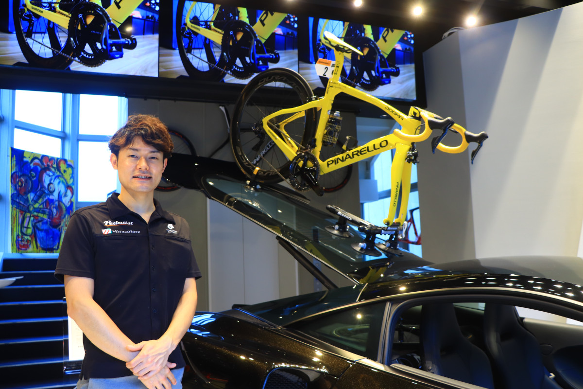 店長を務める福本さん 後ろにはエガン・ベルナルの実車が