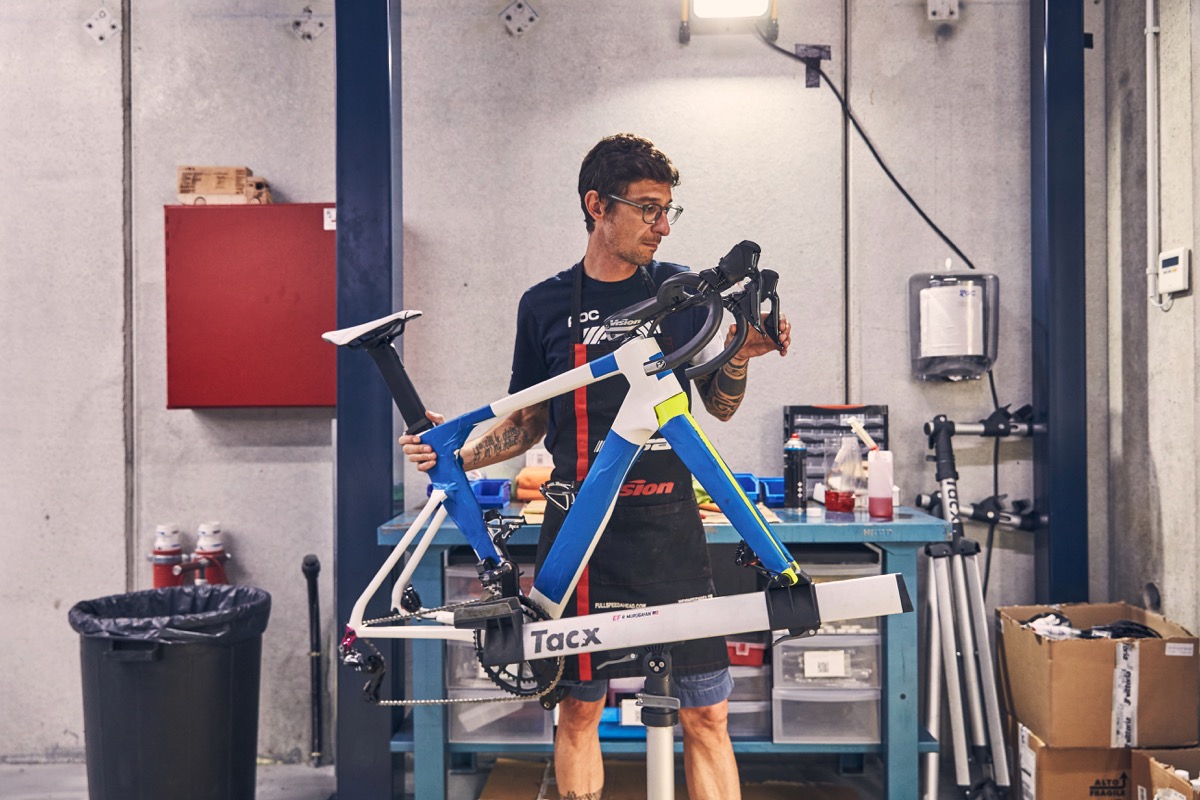 チーム拠点でジロ・デ・イタリアデザインのバイクを組み上げるメカニック