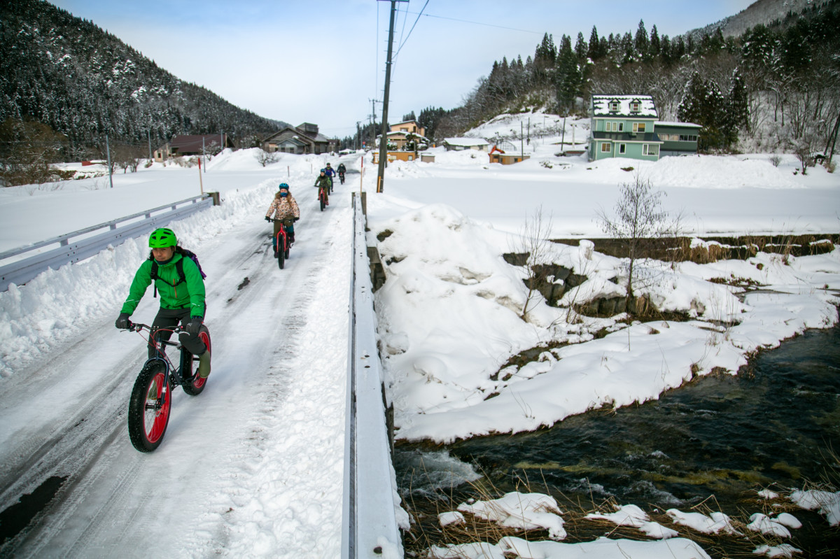 雪解け水が流れはじめた川を渡っていく