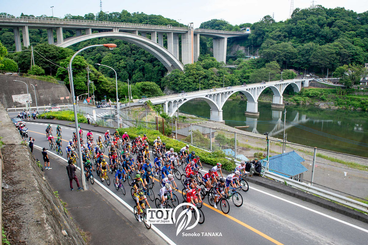 東京五輪ロードレースでも通過した新旧小倉橋をバックに進む集団（写真は2021年）