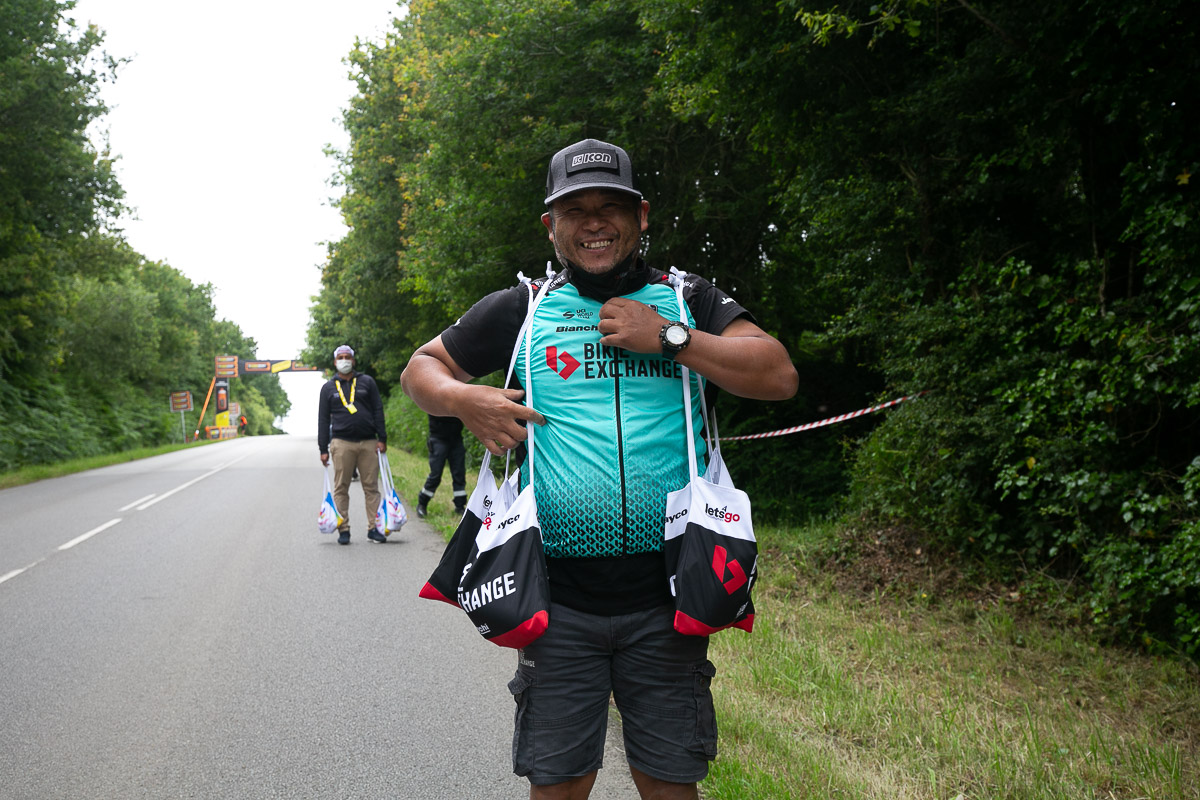 バイクエクスチェンジの宮島正典マッサーがサコッシュを持って選手を待つ