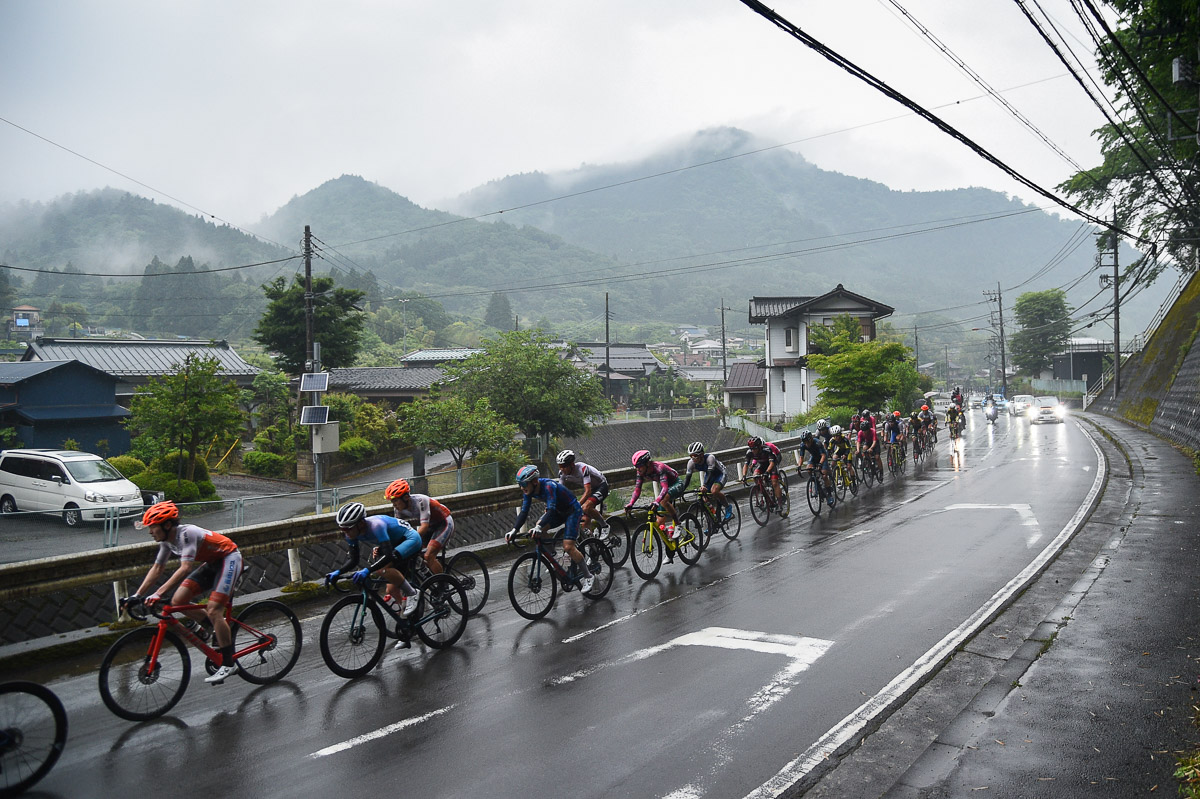 雨に煙る山間の集落を集団が駆け抜けていく