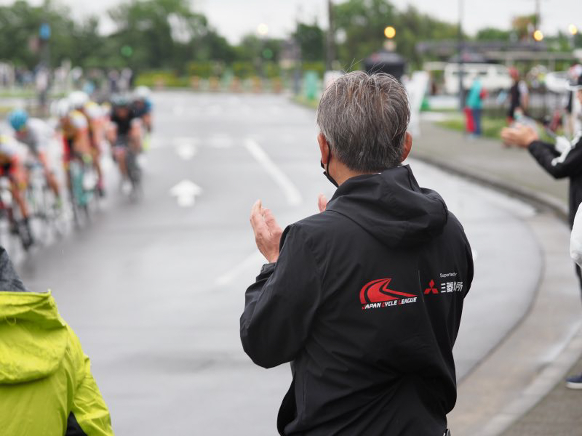 雨のなかレースを走る選手たちにエールを送る片山右京チェアマン