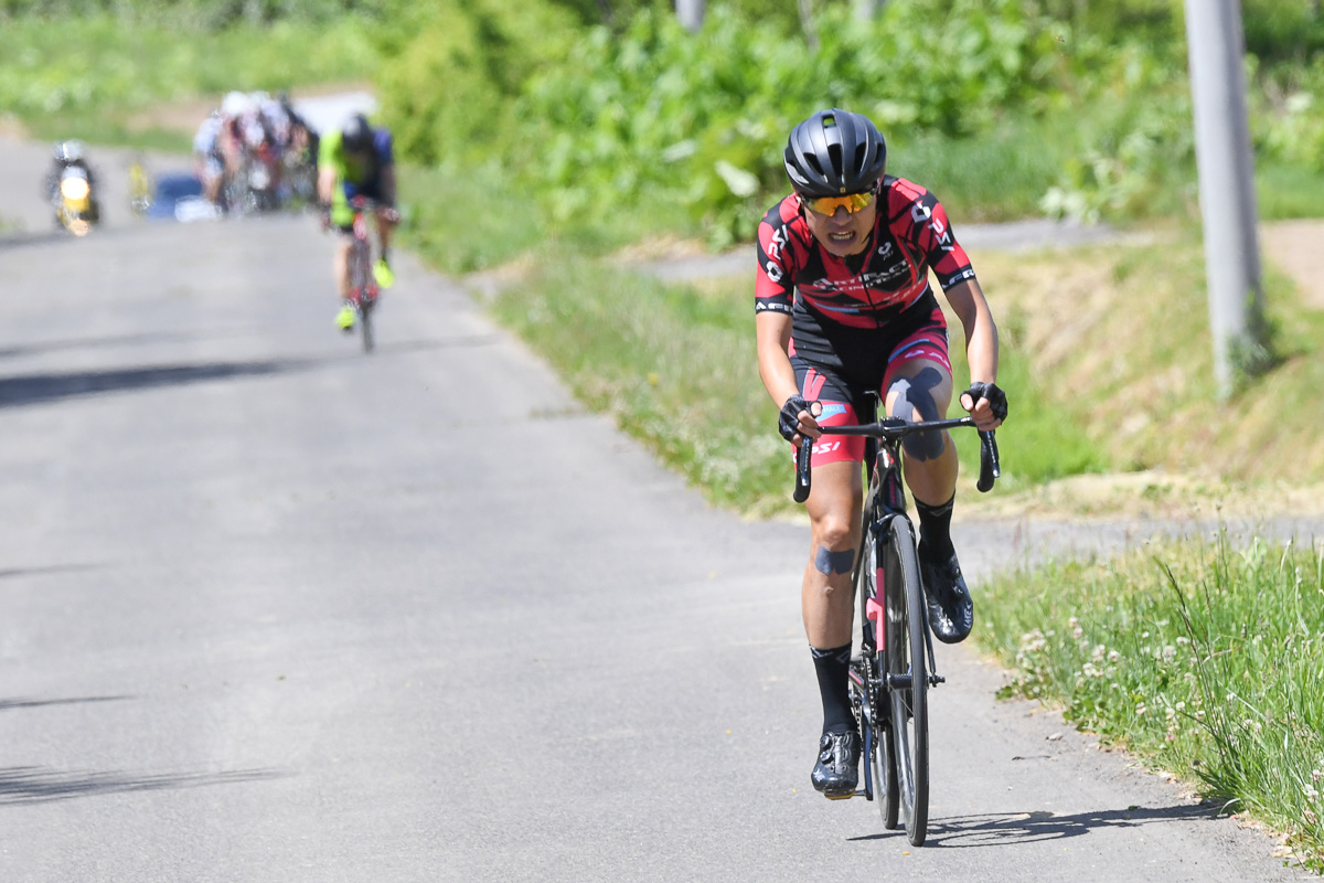 残り10kmを切り独走する石井祥平（アーティファクトレーシングチーム）85km参加者の後方に追走集団が迫る