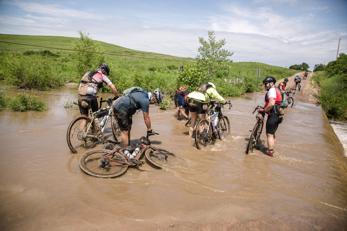 バイクにまとわりつく泥を川で洗い落とす。かなり時間がかかった
