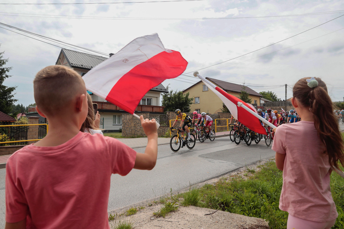 多くの観客がポーランド国旗を手に沿道で応援する