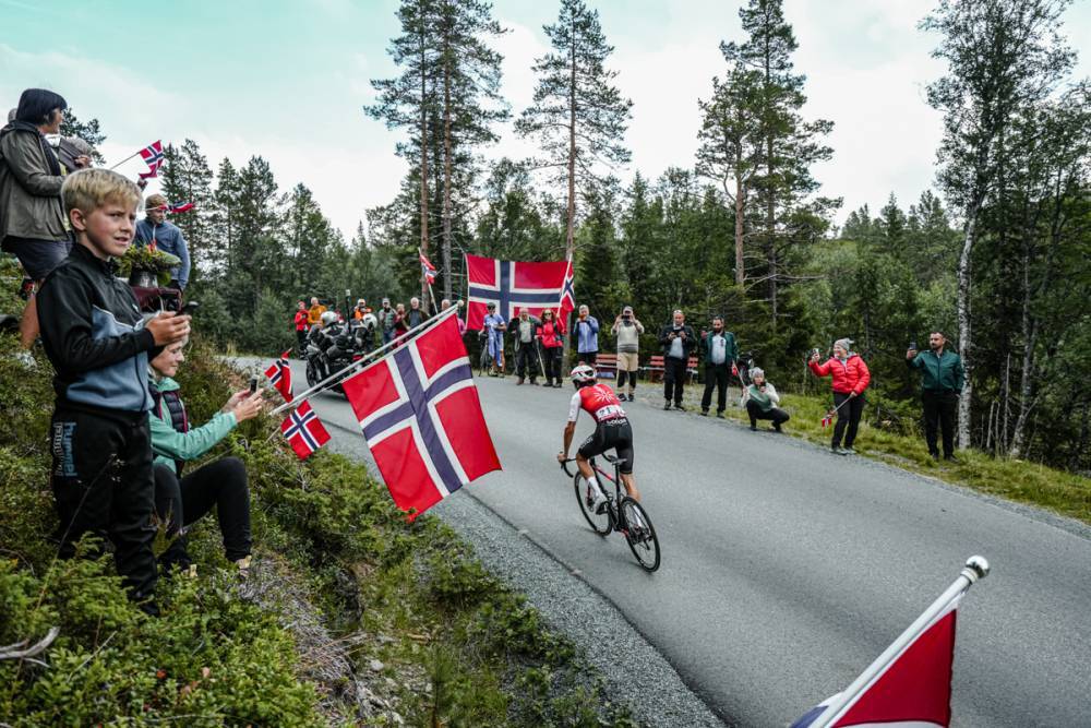 ノルウェー国旗を手に応援する観客の中を突き進むヴィクトル・ラフェ（フランス、コフィディス）