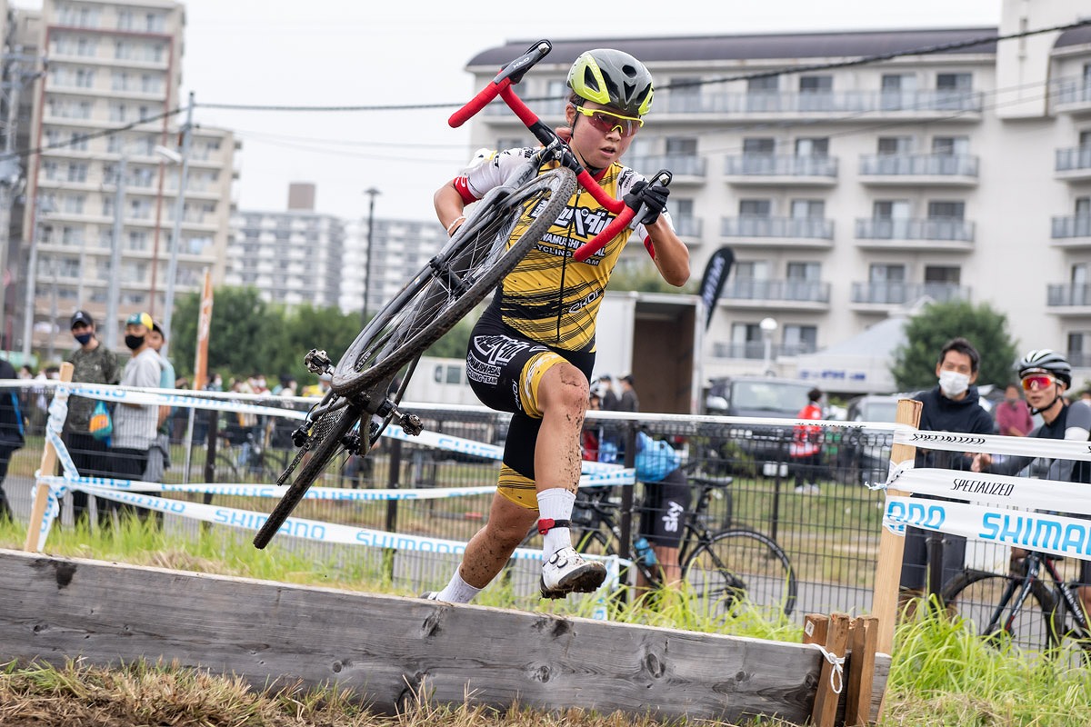 シケインを担いで越える小林あか里(弱虫ペダルサイクリングチーム)