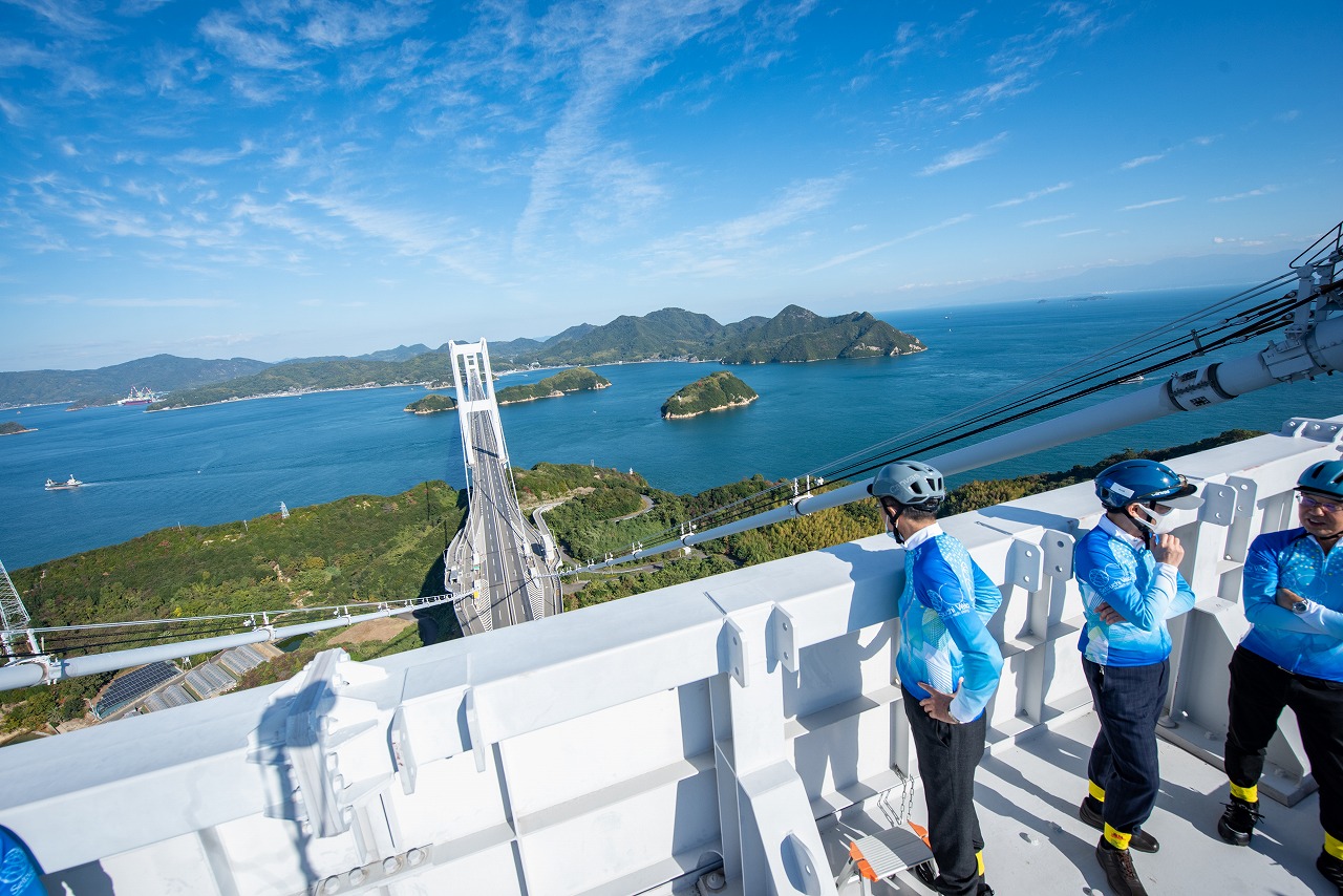  e-bikeライドの途中で、来島海峡大橋の主塔に登る会議出席者ら 