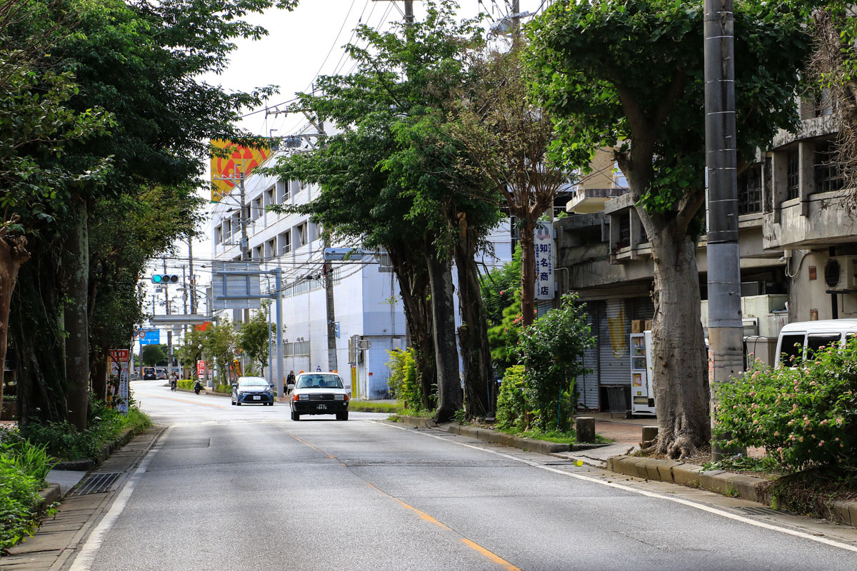 オリオン坂を越えて名護市街へ。平坦路の先にスーパーサンエー（右）