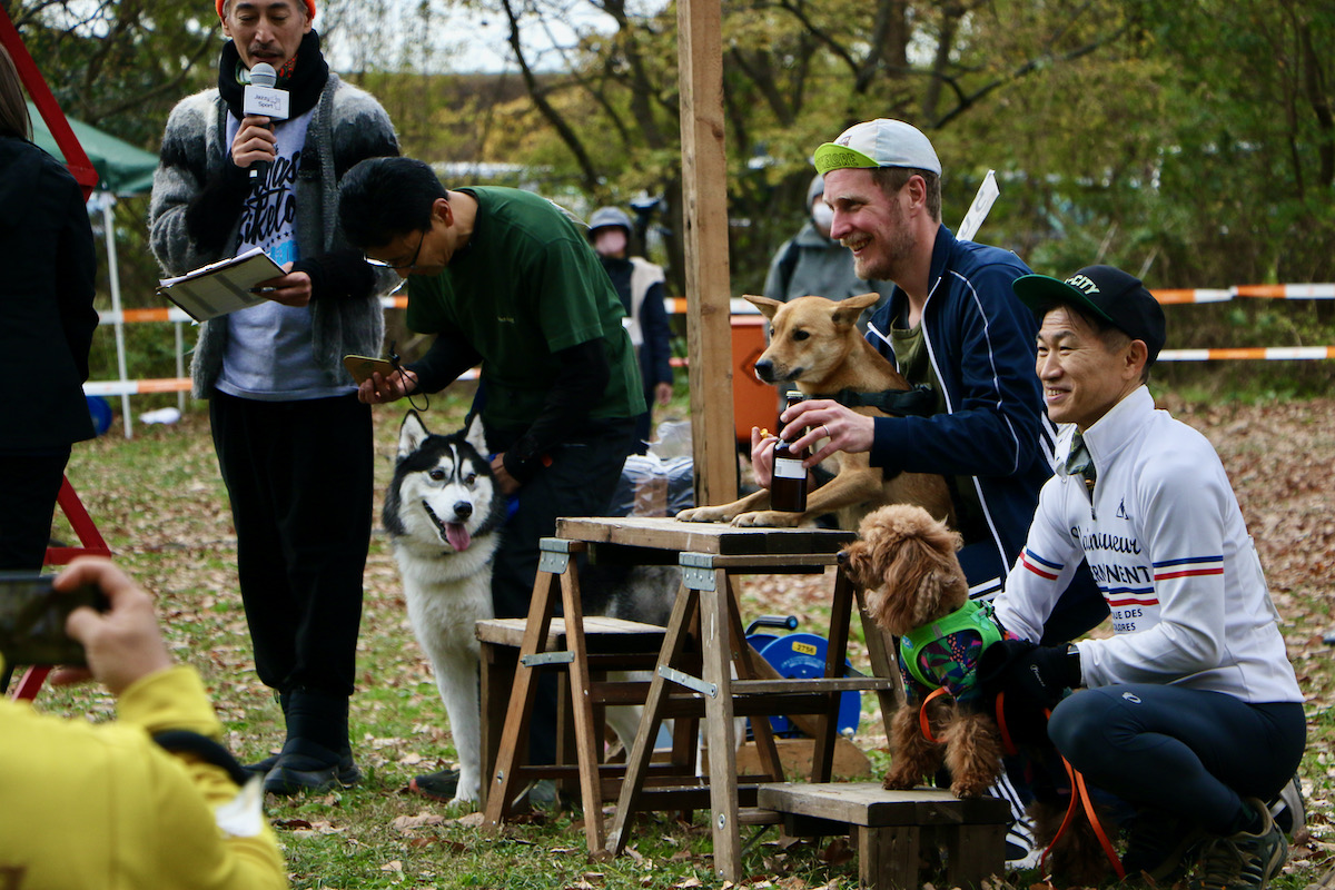 カニクロス（犬とランニンング）の表彰式。優勝賞品のビールには一切の興味を示さない優勝犬