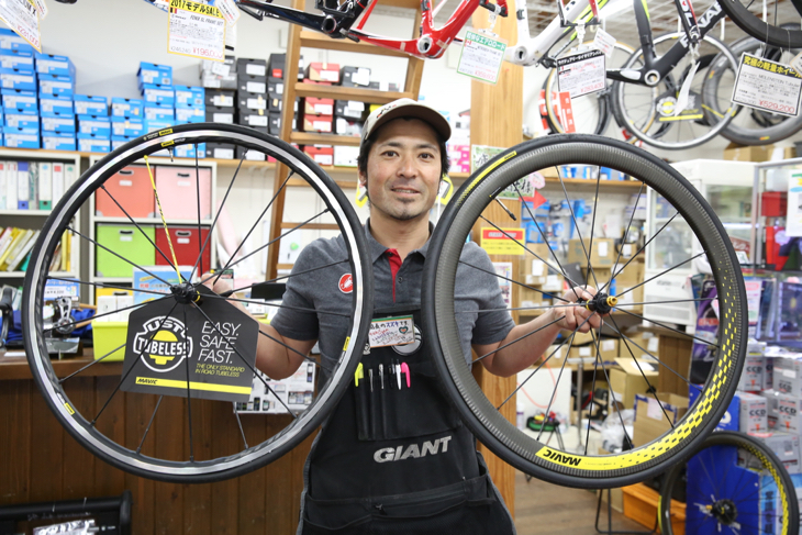 貸し出し用マヴィックホイールを持つ、オーナーの鈴木卓史さん。レンタル用アイテムは非常に豊富だ